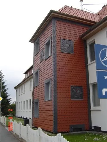 Seitenansicht der Biberschwanzbekleidung mit integrierten Schieferornamenten mit verschiedenen Applikationen