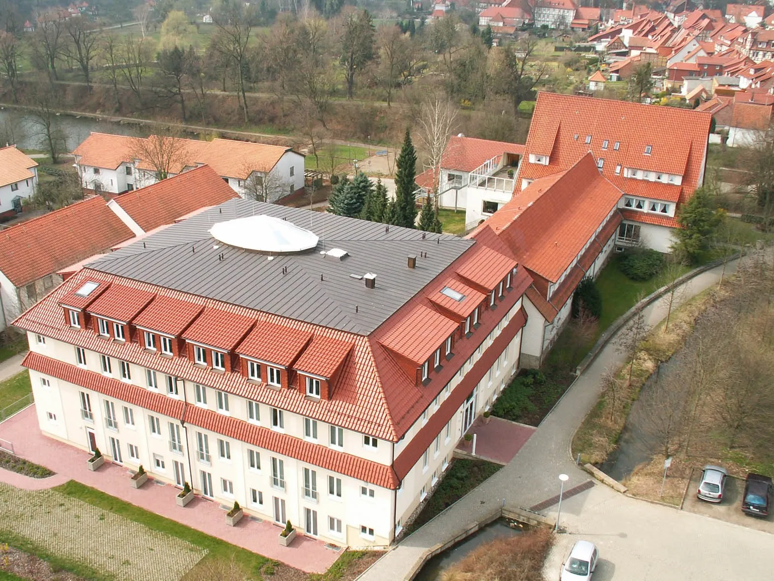 Kombination aus Ziegeldach und Kupferstehfalzdach mit ellipsenförmiger Lichtkuppel